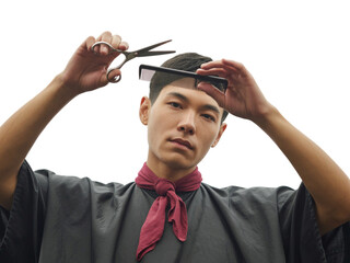 Non-binary barber skillfully cuts hair with scissors and comb representing inclusivity in beauty transparent background