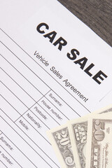 Form of vehicle sales agreement and dollar banknotes. Inscription car sale. Sales, purchases new or used vehicle