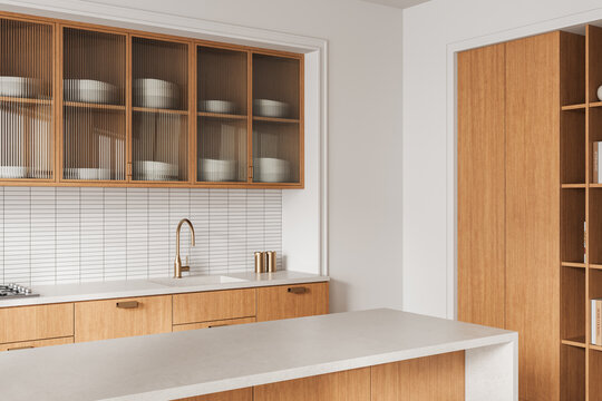 Modern minimalist kitchen interior with wood cabinetry, fluted glass doors, white tile backsplash, and brass fixtures in stylish neutral design concept. 3D Rendering
