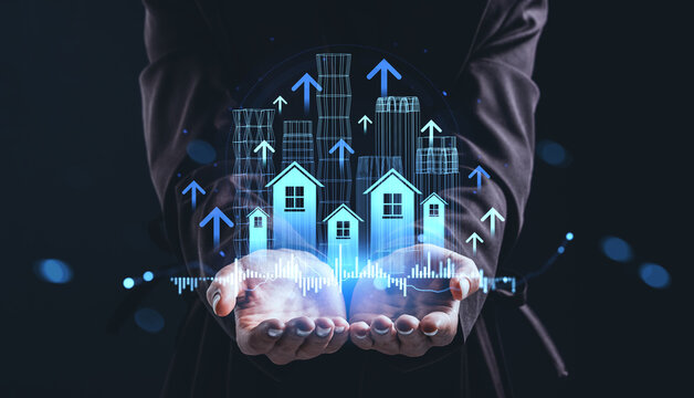Real estate market growth concept with digital houses and upward arrows held in businessman hands on dark background with data visualization chart.