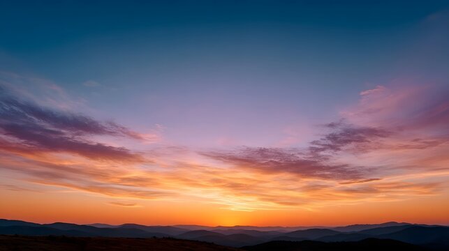 Majestic sunset sky with vibrant gradient colors over silhouetted mountains