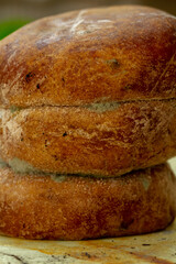 A vertical close-up photograph of stacked, round pia pastries. Patches of blue-green Penicillium mold are visible, indicating advanced food spoilage.
