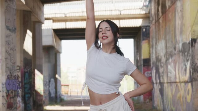 Young woman dancing kpop in an urban underpass, slow motion, 120fps