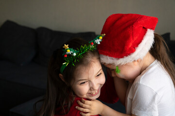 Sisters in Christmas pajamas hug each other