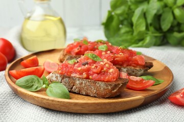 Tasty bruschettas with tomatoes and basil on table, closeup