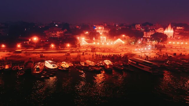 Night drone footage of Assi Ghat and Ganga River in Varanasi. Glowing lights, boats, and reflections create a peaceful spiritual atmosphere along the ghats of Banaras.