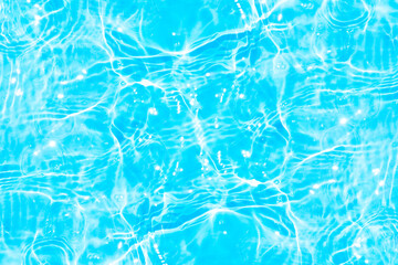 Blue water with ripples on the surface. Defocus blurred transparent blue colored clear calm water surface texture with splashes and bubbles. Water waves with shining pattern texture background.