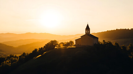 Sunset bathes a hillside church in golden light, casting long shadows. The mountains in the distance add depth. The sky glows with a warm, inviting light. Peaceful.