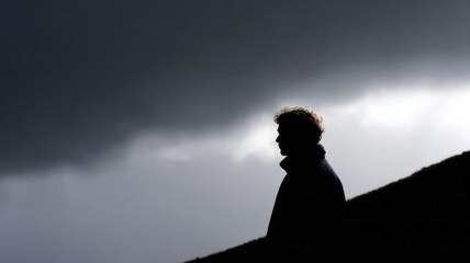 A lone silhouette stands against brooding storm clouds, capturing introspective solitude on Lost Penny Day, embracing shadow poetry