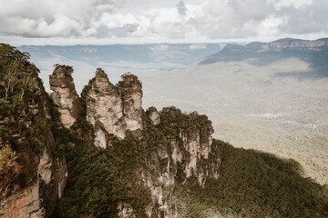 Beautiful mountain landscape of The Three Sisters rocks covered by green outdoor at daytime during winter at Echo Point Katoomba in the Blue Mountains in Australia.