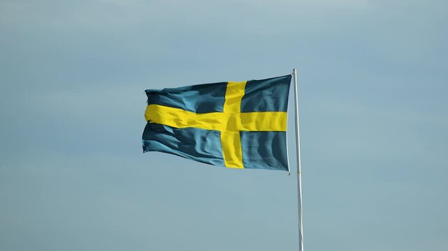 Swedish flag waving against blue cloudy sky