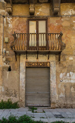 A door in an historic old building in Piazza Bologni in Palermo, Sicily, Italy. A former shop doorway. Above, a weathered sign reads "incisore" ("engraver")