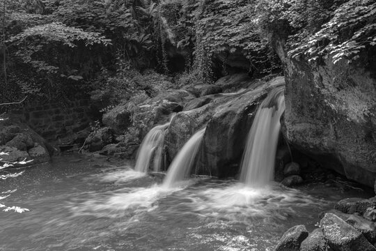Schiessentmpel Waterfall water flowing in the Mullerthal region of Luxembourg's Little Switzerland in black and white