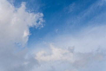 A clear blue sky background with layers of thin, wispy cirrus and altocumulus clouds. A bright, sunny day scene representing good weather and serenity.
