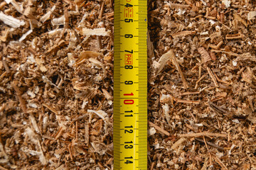 Gros plan sur un mètre pliant reposant sur de la sciure.