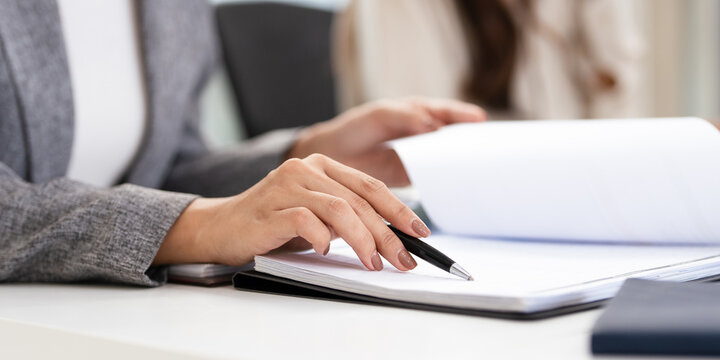 close up hands of Business partners working with analysis report and advisor showing plan, Two businesswoman working with Financial analysts reports and planning investment at office. - Powered by Adobe