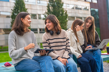 Young female student group discussing outdoors at university campus