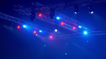 Stage lights shining brightly, illuminating the scene with dynamic colors. A stunning display of red and blue hues creates a captivating atmosphere Stock Video - Powered by Adobe