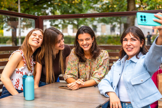 Young women friends taking selfie with smartphone outdoors