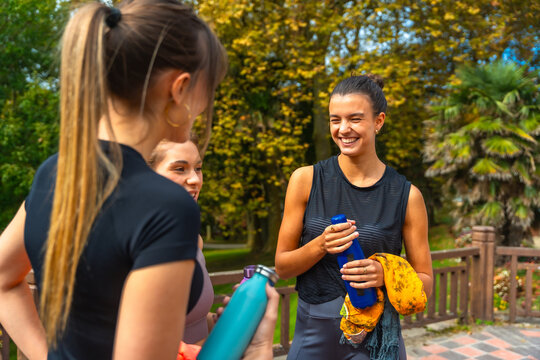 Women friends talking and smiling after workout in park - Powered by Adobe