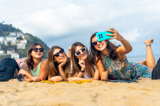 Young women friends enjoying vacation taking selfie on beach
