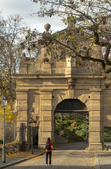 Vertical photo of a lone tourist takes a photo of the entrance gate to Vysegrad in Prague in autumn.