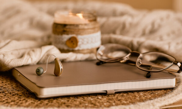 Stylish hearing aid on a soft notebook showcases innovative solutions in audiology and sound enhancement