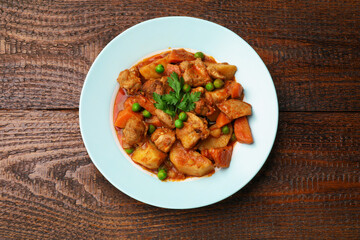 Delicious cooked stew on wooden table, top view