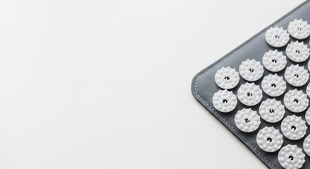 An acupuncture mat on a white surface provides a clean and minimalist image for wellness and self care