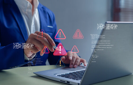 Cybersecurity concept showing businessman analyzing laptop screen with digital warning alert icons. Perfect for illustrating data protection, cyber risk management, or online security issues.