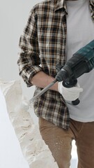 Close up of unknown male construction worker wearing beige checkered shirt and protective gloves,...