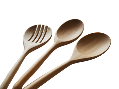 Three natural wooden kitchen spoons including a slotted server and two solid serving spoons isolated on a dark background.