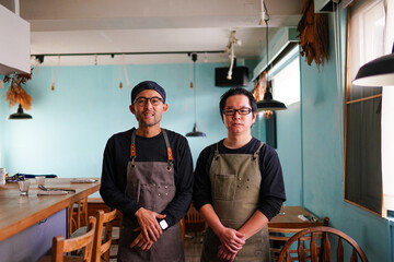two chefs wearing aprons standing together 