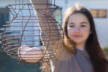 Smiling girl holds a rusty wire egg cup