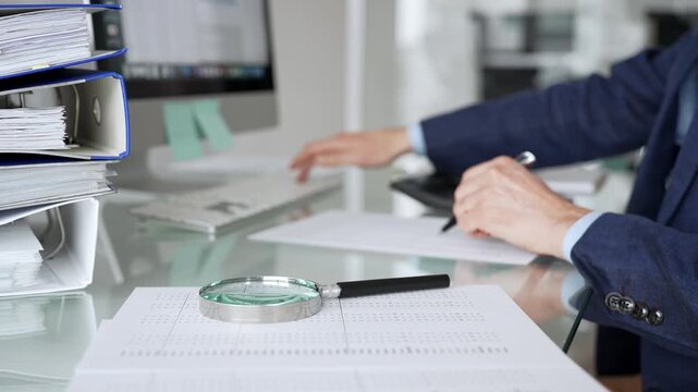 Accountant doing financial audit, calculating taxes with calculator, business bookkeeping, reviewing corporate report. Audit and taxes in business