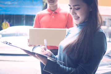 A person wearing red T-shirt is delivering parcels to a satisfied client. Friendly worker