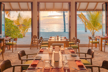 Cozy tropical resort open-air restaurant interior sunset golden hour view dining area tables chairs Luxurious holiday fine dining experience lifestyle background