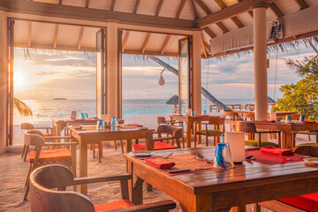 Luxurious modern resort open-air restaurant interior design sunset golden hour view dining area furniture wooden floor Tropical summer holiday fine dining luxury lifestyle experience