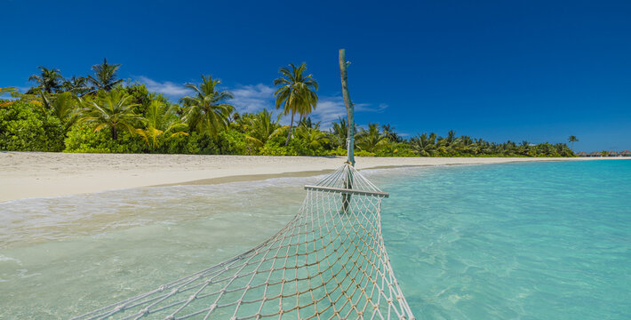 First person view hammock background clear turquoise ocean water white sandy beach lush green palm trees sunny blue sky. Relaxing tropical paradise relaxation summer holiday travel escape destination