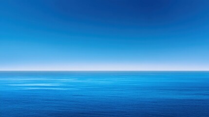 Obraz premium Tranquil Blue Ocean View Under a Clear Sky with Gentle Waves and a Calm Horizon at Sunrise or Sunset for Peaceful Background or Leisure Use