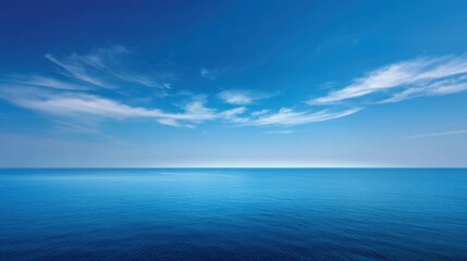 Obraz premium Serene Blue Ocean Under Clear Sky with Soft Clouds on the Horizon for Tranquil Nature and Relaxation Themes in Photography