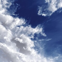 Obraz premium Beautiful Blue Sky with Soft White Clouds Showcasing a Bright Natural Landscape Perfect for Backgrounds and Creative Projects