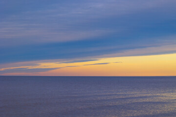 A minimalist landscape of a summer sunset at the beach of Baltic Sea. Colorful scenery in Latvia, Europe.