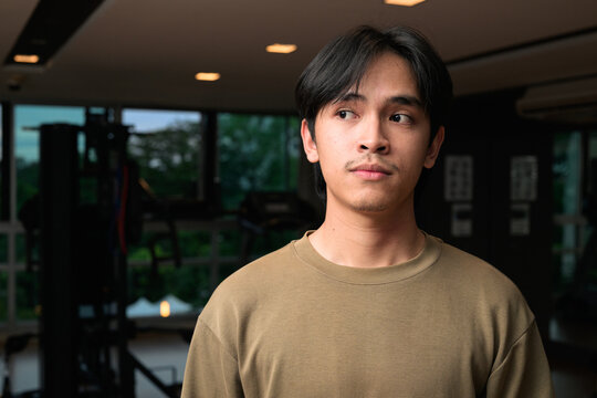 Portrait of handsome Young Asian Thai man in fitness gym at night