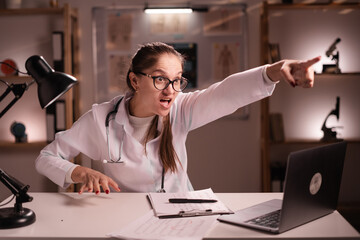 young female doctor gets angry during patients visit, yells, points at door and says Get out