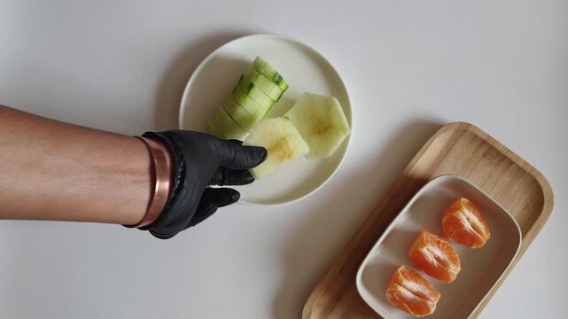 Hand Placing Apple Slices on White Plate &mdash; Fresh Fruit Concept