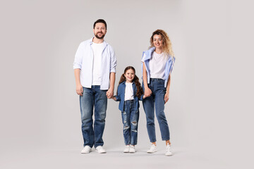 Obraz premium Happy family holding hands on grey background