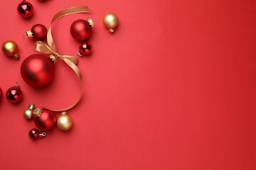 Beautiful Christmas tree ornaments on red background, flat lay. Space for text