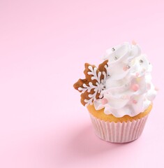 Tasty cupcake with Christmas decor on pale pink background, closeup. Space for text