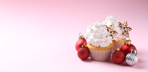 Tasty cupcakes with Christmas decor on pale pink background, closeup. Space for text